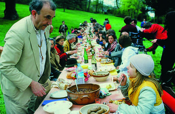 Daniel Spoerri à la table du banquet de L'enterrement du tableau-piège en 1983